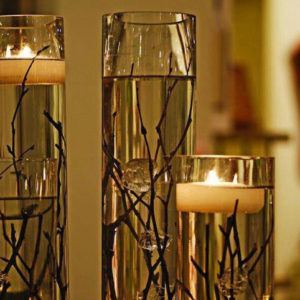 Tall glasses with twigs and floating candles