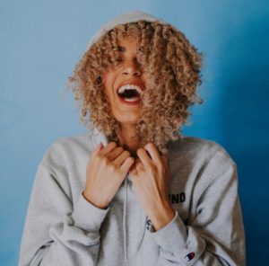 Woman with curls in grey hoodie