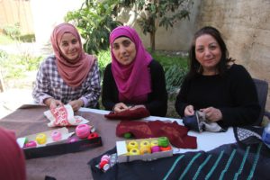 Palistinian women entrepreneurs embroiding fabric for Darzah