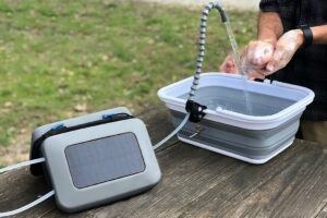 Somebody washing their hands with the GoSun FLow portable water purifier
